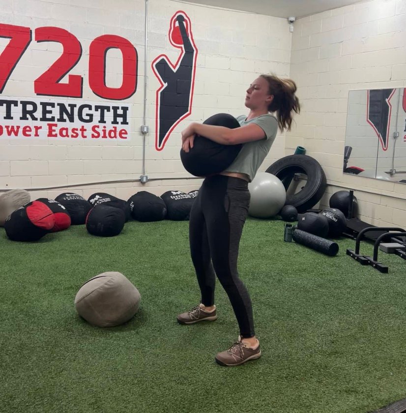 Trainer throwing medicine ball in workout